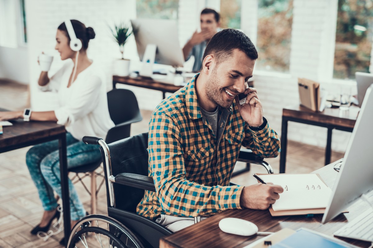 Man on Wheelchair Write Notes and Talking on Phone