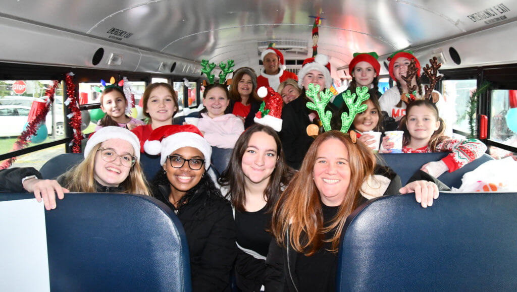 The 8th Annual Kids Need More Holiday Cheer Bus Elf Ride
