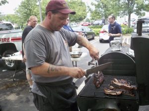 A member of the Westbury Fire Department hard at work on the grill. 