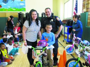 Christian Amaya (center) was the lucky recipient of a new bike.He is pictured here with teacher Rhina Mercado and officer Todd Aiken.  