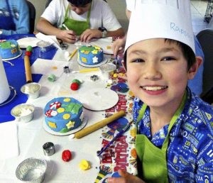 Children enjoy designing cakes at a Create A Cake birthday party