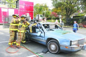 Firefighters demonstrated vehicle extrication, which sometimes involves removing the front window using a battery-operated cutter or removing the doors and roof using hydraulic tools.