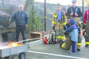 Alert Chief James Neubert oversaw a demonstration on how to use a fire extinguisher on a trash fire.