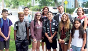 Oyster Bay High School principal Sharon Lasher (back) with assistant principals Tim McCarthy and Lara Gonzalez brace the rain to welcome students back to school.