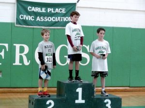 Winner of the fifth and sixth grade boys’ division Jack Hommel, stands atop the podium. He is flanked by second place winner Aiden Reid and third place recipient Philip Alfieri. 