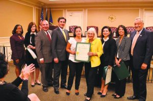 XXXXX (center) was recently recognized by the Town of North Hempstead board. 