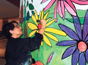 Patty Eljaiek works on a portion of the mural. 