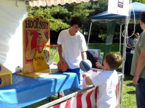 Kids take hoop shots at the Party in the Park carnival.