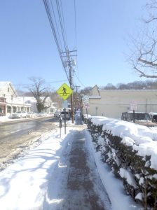 A long stretch of Old Northern Boulevard with clear sidewalks.