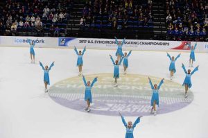 Skating C Amie in the center on top of letter I on ice