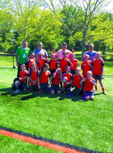 The team, sitting first row, from left: Eleanor Dillmeier, Giana Cerrone, Nicoletta Tsiamis, Lauren Perfetto, Ava St. Jeanos, Savana Connolly, Catherine Hannan; second row: Gabriella Devito, Leyna Schlaefer, Catherine Bachman, Chrisi Ladopoulos, Hayden Gore, Caroline Arellano, Siri Craven; top row: Trainer Dave O’Keefe, Coach Christopher St. Jeanos, Assistant Coach Paul Ladopoulos, Assistant Coach Keith Devito; Missing from the photo are Olivia Aversano and Katherine Collard.