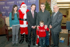 Valon Syla stands with his father, along with Santa Claus and St. Francis staff members  