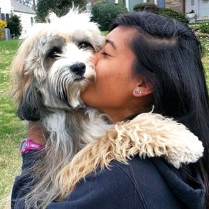 Dan’s Dog Walking & Pet Sitting field manager Lara snuggles Tibetan terrier Kody. Snuggling with pets can bring comfort to someone with cancer and other illnesses.