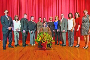 Gathering around the auditorium dedication plaque, from left: Principal Gerald Cozine; reading teacher Betty Brody; members of Dan Tomaselli’s family—David Tomaselli, Christina Tomaselli, Meg Tomaselli, Kit Templer, Jack Templer, Patricia Tomaselli, Courtney Tomaselli and Joe Tomaselli; Assistant Principals Jennifer Andersen and Nancy Gunning; and art department head Elaine Brendel. (Photos by Jeff Barlowe)