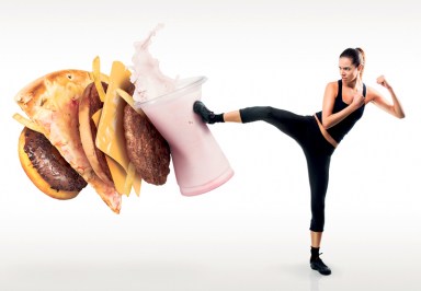 Fit young woman fighting off fast food