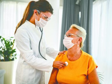 Doctor using stethoscope listening to senior patients breathing