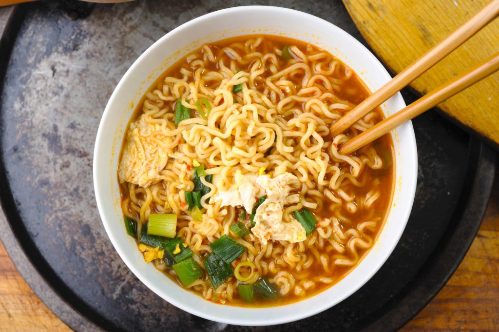 Ramen noodles in broth with chopsticks in a white bowl