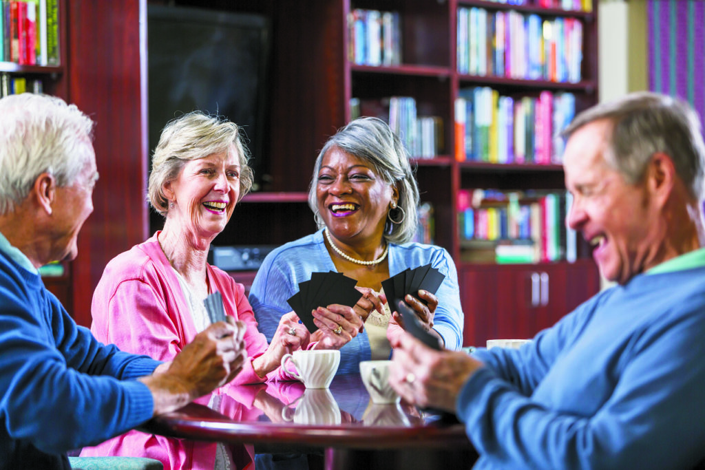 Multiracial group of seniors talking, playing card game