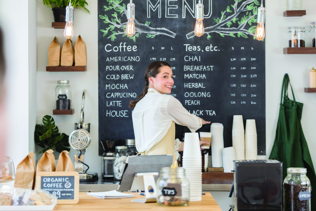 Female barista looks over her shoulder