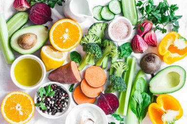 Five best vitamins for beautiful skin. Products with vitamins A, B, C, E, K – broccoli, sweet potatoes, orange, avocado, spinach, peppers, olive oil, dairy, beets, cucumber, beens. Flat lay, top view