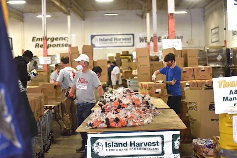 Volunteers are shown on June 29 at an Island Harvest warehouse,  putting together some of the 4,000-plus boxes for a massive food distribution effort on July 1.