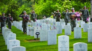 Soldiers flag the graves at Arlington Cemetery.