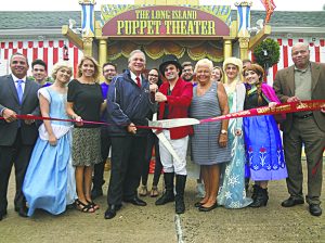 County Executive Ed Mangano helps Anthony Labriola with the ribbon cutting. Next to Mangano is County Legislator Laura Schaefer, while Legislator Rose Marie Walker stands next to Labriola. (Photo by Chris Boyle)