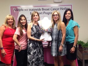 Five of the six creators of “Circles of Support” bring their finished bra to the Adelphi offices. From left: Gyll Sbrocchi, Michelle Krach, Pam Shapiro, Nancy Bauman and Stephanie Castro. Not pictured, Maryann Aidikoff.