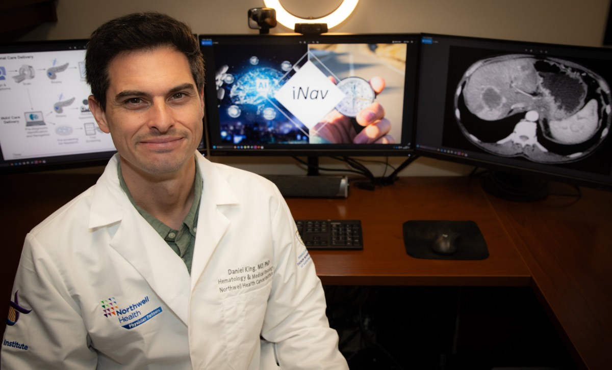 Northwell Health's Dr. Daniel King sitting in front of a computer dispalying the iNav technology