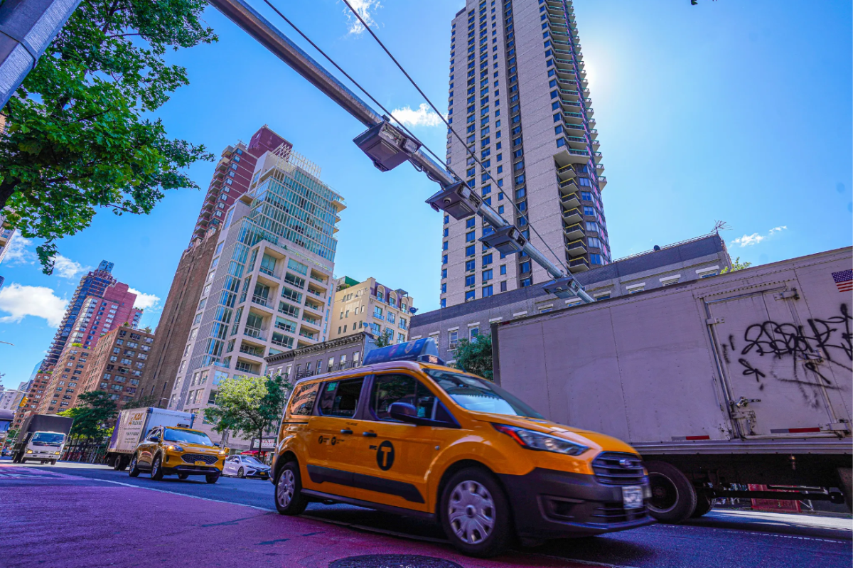 A taxi passes under an unused congestion pricing gantry