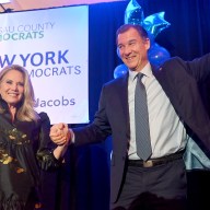 Laura Gillen and Tom Suozzi raise their hands together in victory after both Democrats were elected to the House.