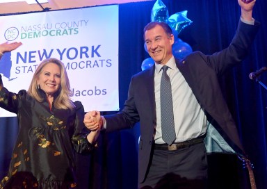 Laura Gillen and Tom Suozzi raise their hands together in victory after both Democrats were elected to the House.