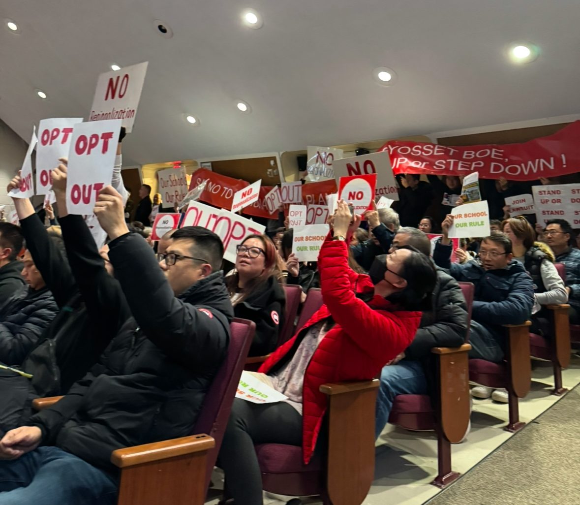 The Syosset community brings "Opt Out" signs to the Dec. 9 board meeting while discussing regionalization