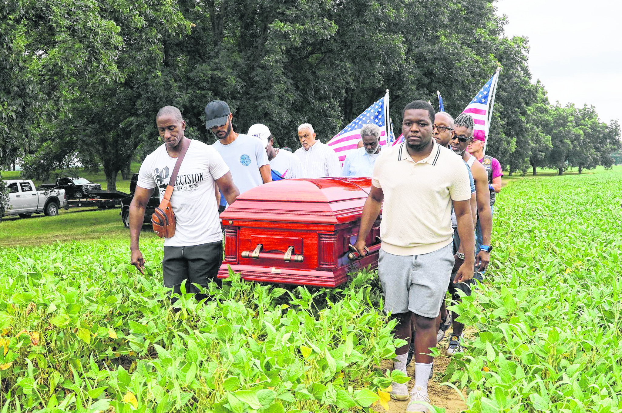 Cheryl Wills’ family members carry U.S. Army Private Sandy Wills’ remains in a coffin away from his unmarked grave.