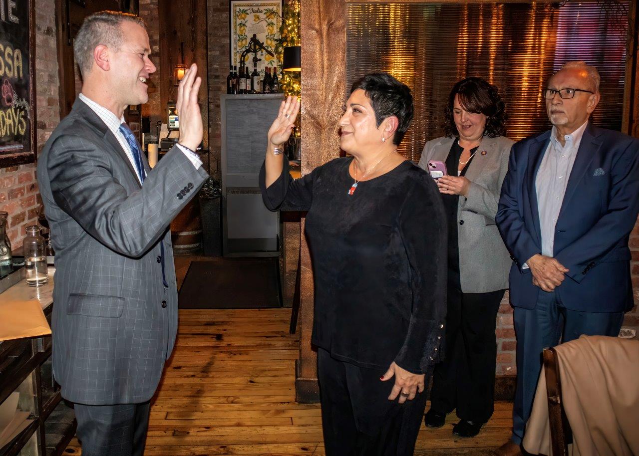 Malverne Mayor Tim Sullivan swearing in Malverne Chamber of Commerce Chairwoman Maria Casini.