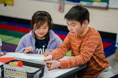 students from the lower grades at Charles Campagne School teamed up with “buddies” from the older grades to make valentines for children in the hospital.