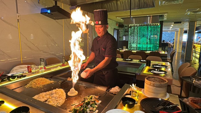 Hibachi chef makings a flaming onion volcano for restaurant-goers at DD Soup Dumplings & Hibachi