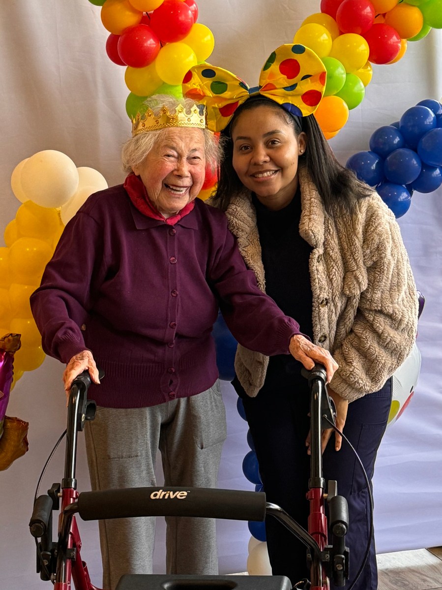 Holocaust survivor Hedy Pagremanski (Page) arrives at the Purim celebration hosted by Selfhelp Community Services with worker Susan Rwle.