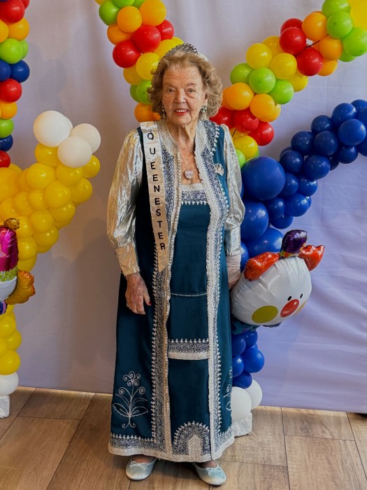 Holocaust survivor Lena Goren poses with a sash reading 'Queen Esther.'