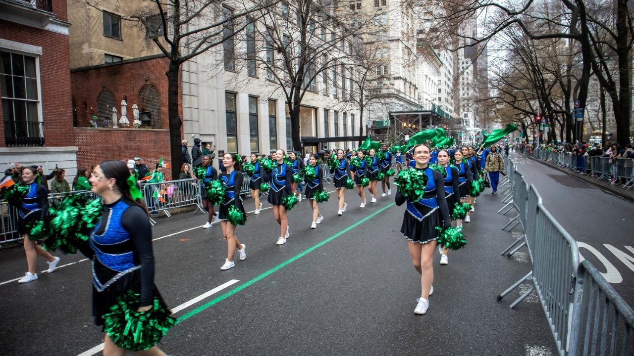 The North Babylon High School kickline team smiled and waved to the crowd during the St. Patrick's Day parade in NYC.