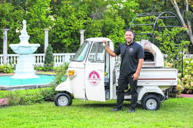 Rob Pellegrino, the founder of unique dining pop-up Pizza Passeggio, poses with his small-but-mighty pizza oven on wheels.