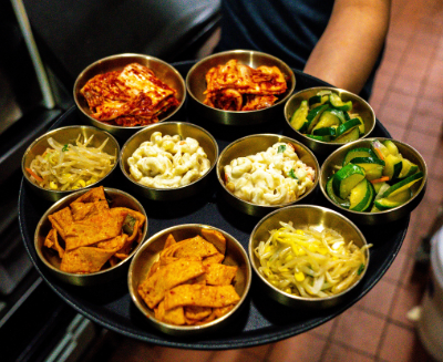 Array of side dishes KuKu Korean Cuisine serves with every table