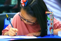 Kexin Su concentrates as she prepares her art competition entry in th Champskid competition on Saturday night.